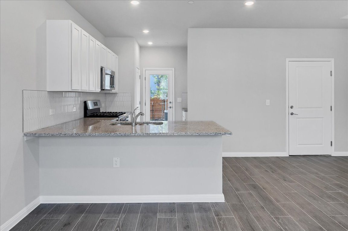 9015 Cattle Baron Path, Unit 1303 Austin, TX 78747 - Photo 6 of 29 a kitchen with granite countertop a stove a sink and a granite counter tops