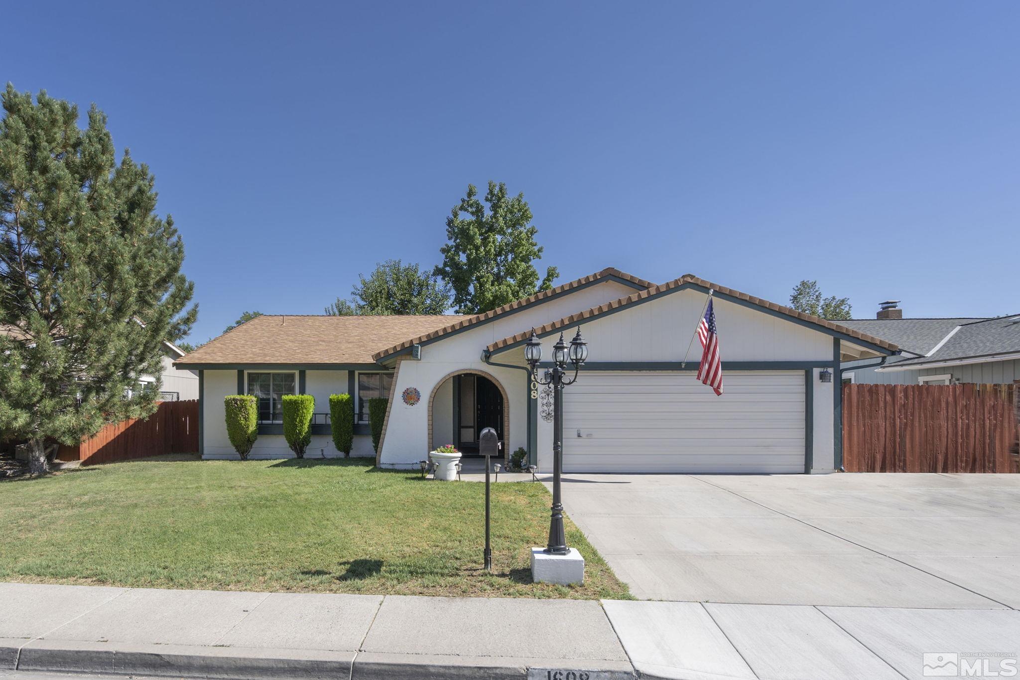 1608 Del Rosa Way Sparks, NV 89434 - Photo 2 of 18 a view of a white house next to a yard with big trees