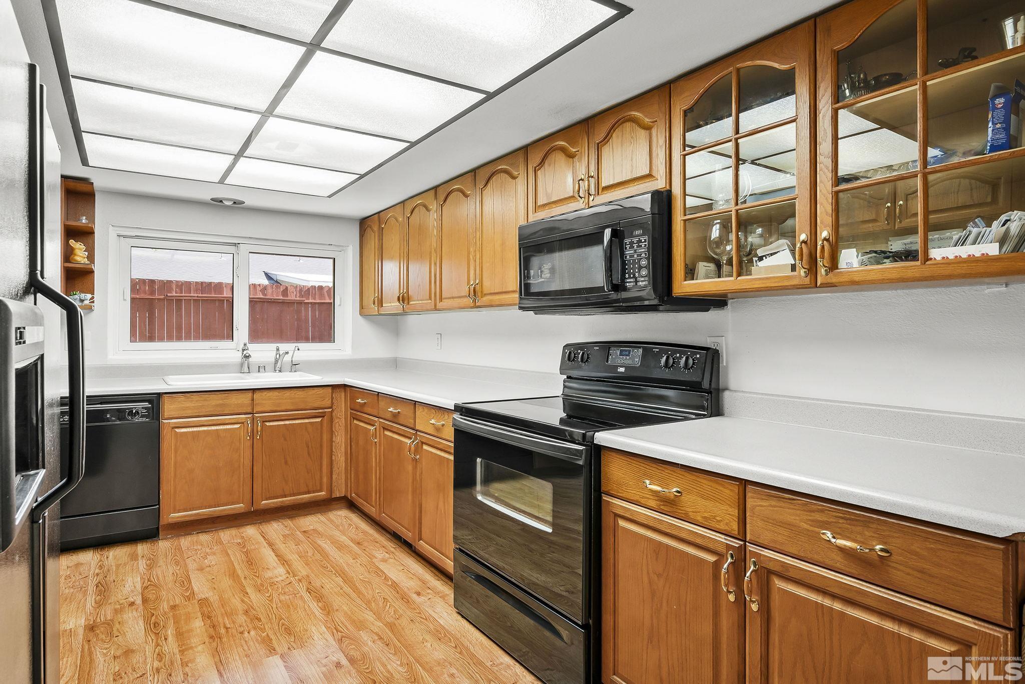 1608 Del Rosa Way Sparks, NV 89434 - Photo 9 of 18 a kitchen with stainless steel appliances granite countertop a stove a sink dishwasher and microwave oven with cabinets