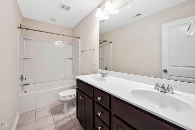 a bathroom with a double vanity sink toilet mirror and shower