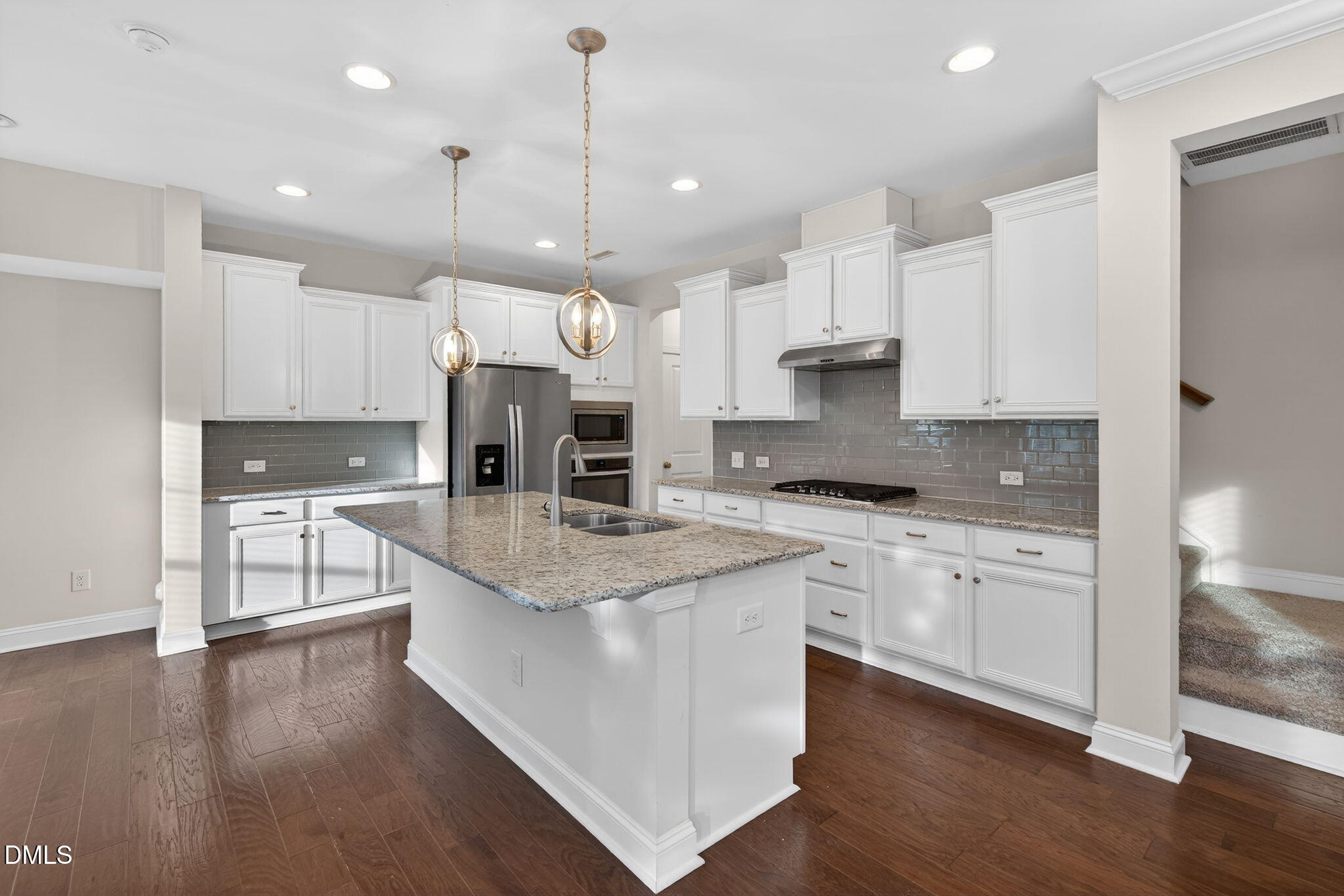 1103 Laurel Twist Road Cary, NC 27513 - Photo 4 of 38 a kitchen with stainless steel appliances granite countertop a stove a sink a refrigerator and white cabinets with wooden floor