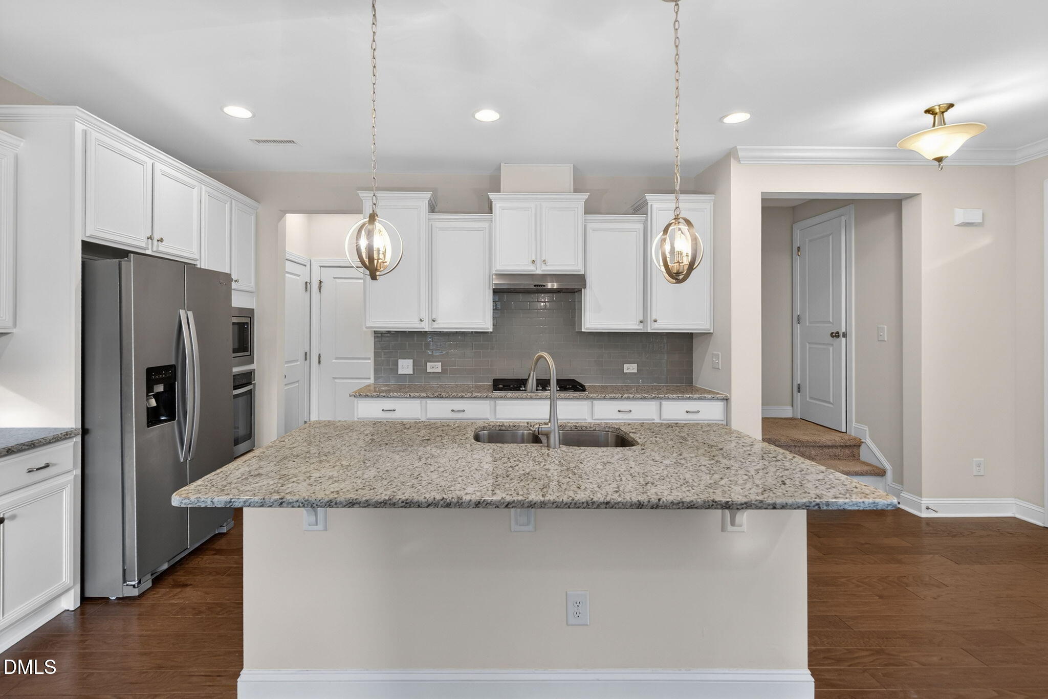 1103 Laurel Twist Road Cary, NC 27513 - Photo 6 of 38 a kitchen with kitchen island granite countertop a sink a center island a stove and a refrigerator
