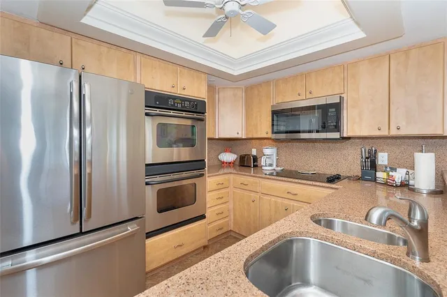 a kitchen with granite countertop a sink stainless steel appliances and cabinets