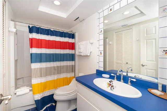 a bedroom with two beds and a dresser next to a window