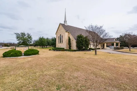 a view of a white house with a large windows and plants