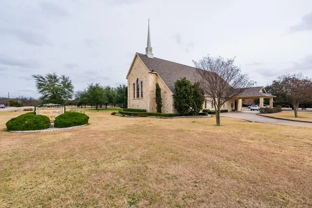 a view of a white house with a large windows and plants