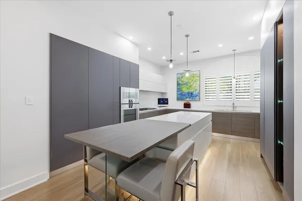 a kitchen with kitchen island a wooden floor and white appliances