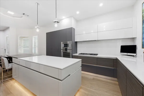 a kitchen that has a sink a stove and chairs