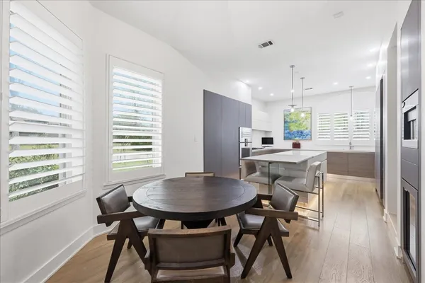 a kitchen with a table chairs a sink dishwasher window and dining table