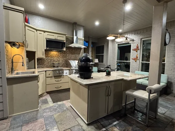 a kitchen with stainless steel appliances kitchen island granite countertop a sink and cabinets