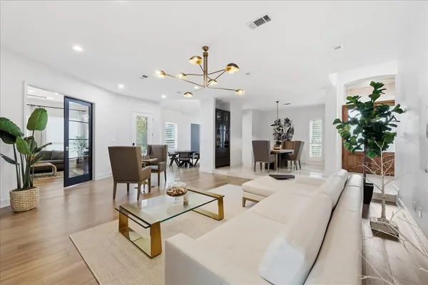 a living room with furniture a chandelier and a potted plant