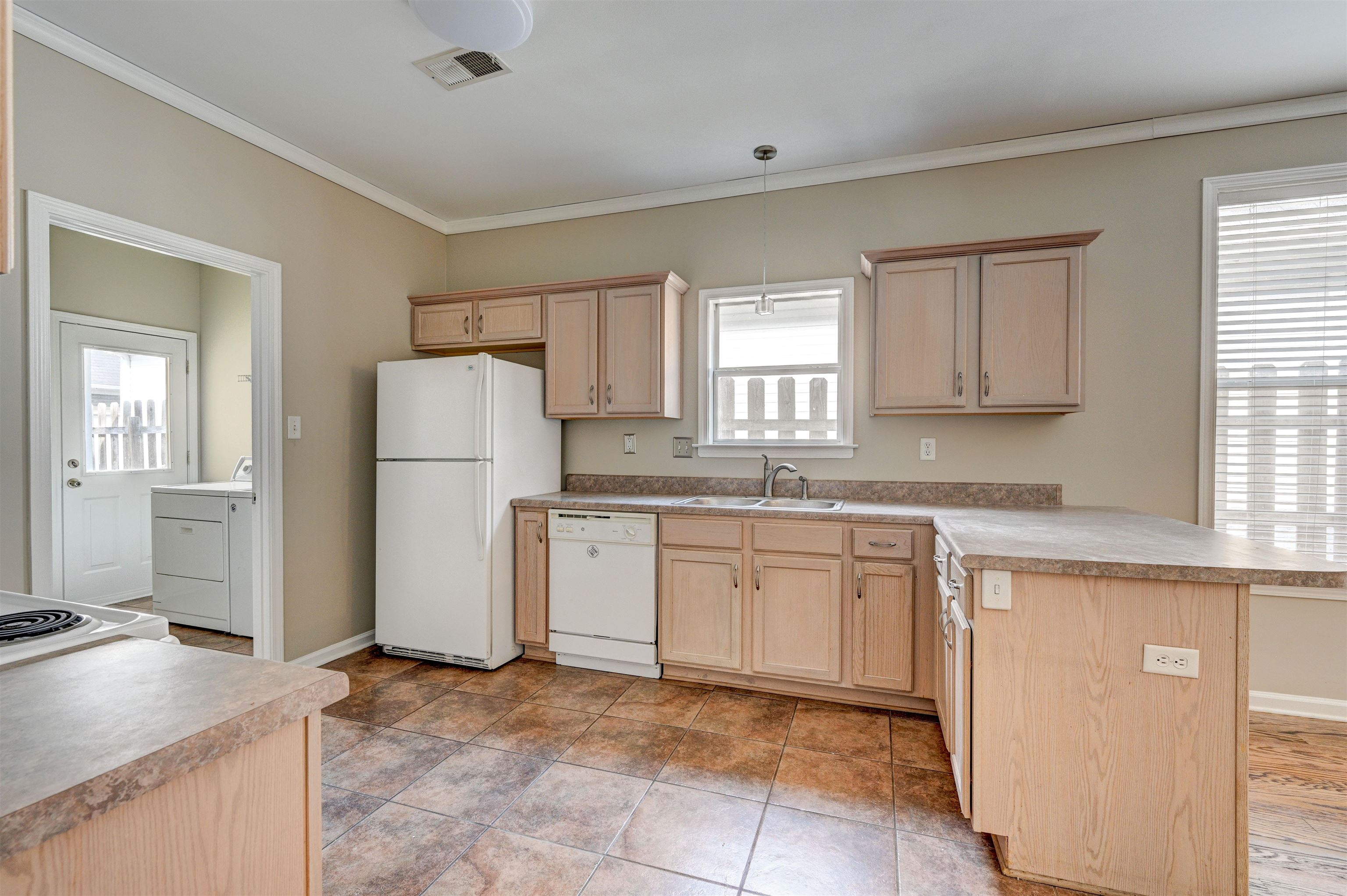 1355 Island Ridge Drive Memphis, TN 38103 - Photo 7 of 21 a kitchen with a refrigerator and white cabinets