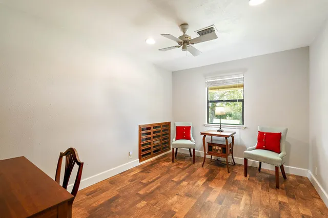 a view of a workspace with furniture and a window