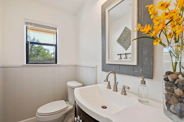 a bathroom with a toilet a sink and a mirror