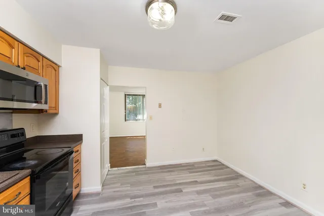 a kitchen with stainless steel appliances granite countertop a stove a sink dishwasher and a microwave oven with cabinets