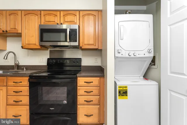 a view of a kitchen with wooden floor and stainless steel appliances