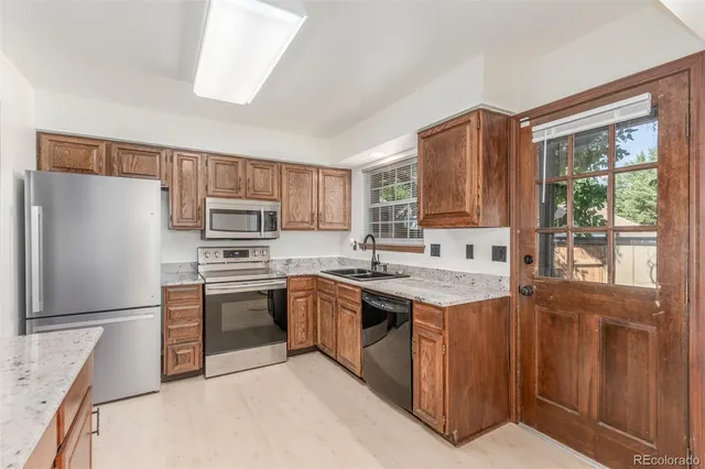 a kitchen with stainless steel appliances granite countertop a stove a sink dishwasher a refrigerator and a stove