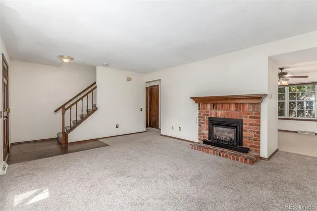 a view of an empty room with a fireplace and a window