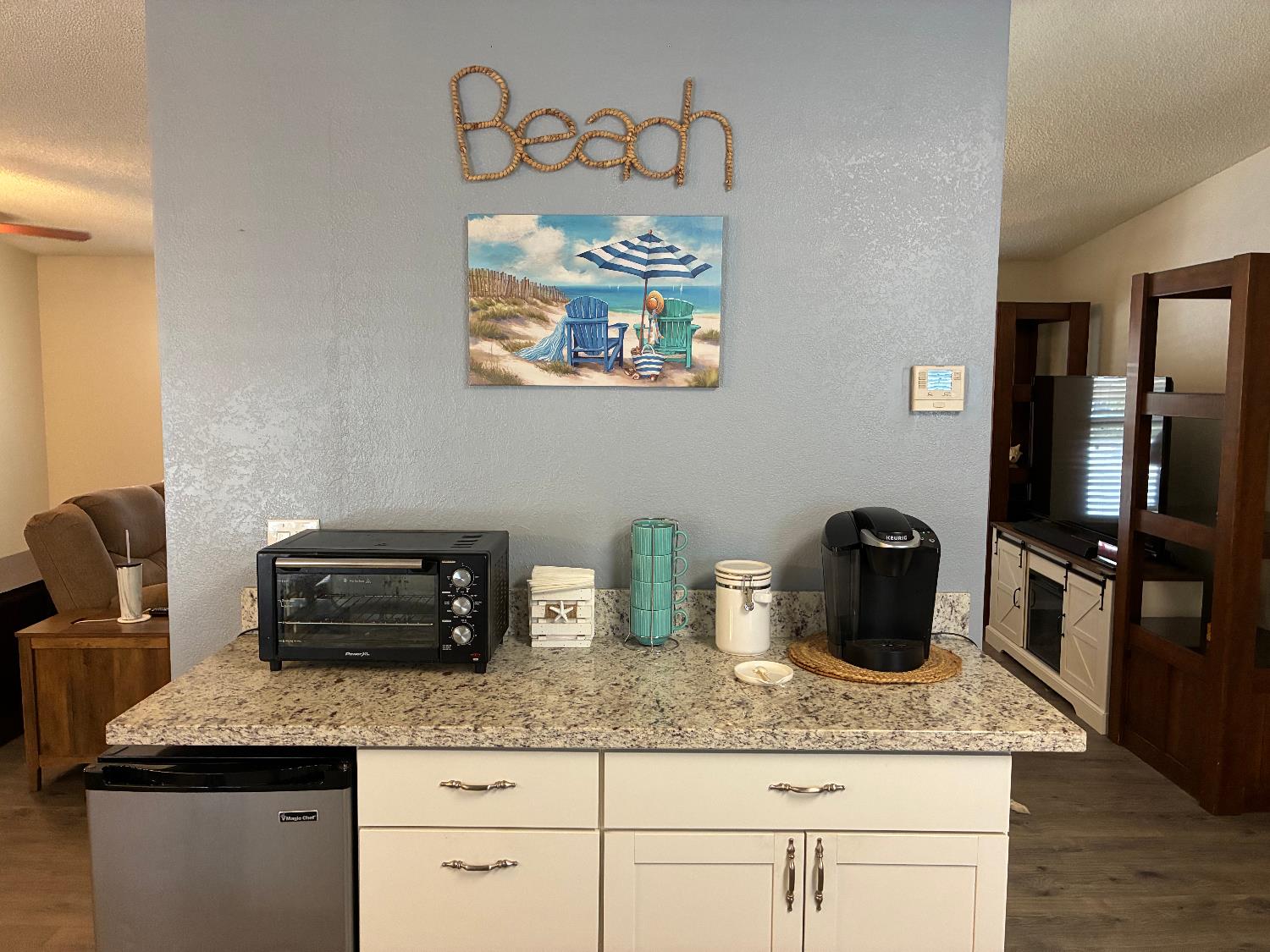 a kitchen with granite countertop a sink a stove and wooden floor