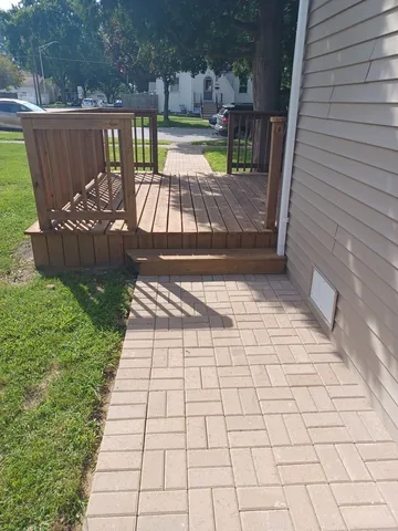 a view of a patio with a dining table and chairs with wooden floor and fence