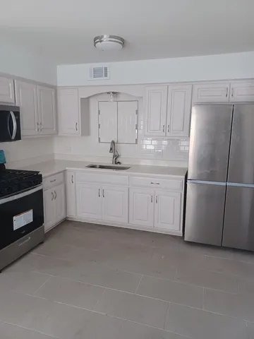 a kitchen with white cabinets and white appliances