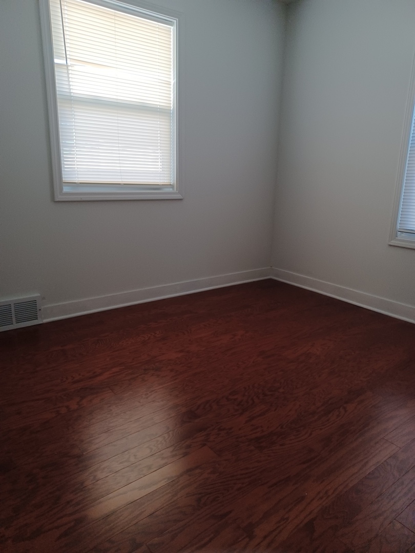9135 South 53rd Avenue Oak Lawn, IL 60453 - Photo 6 of 9 an empty room with wooden floor and windows