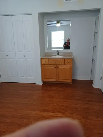 a view of kitchen and empty room with wooden floor