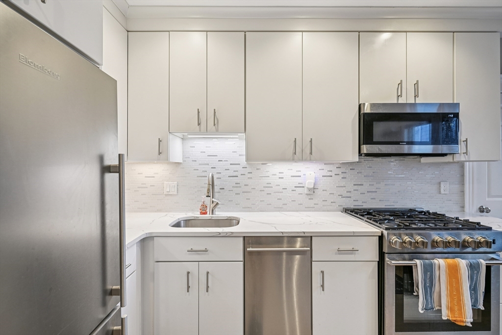 600 Shirley Street, Unit 4 Winthrop, MA 02152 - Photo 14 of 29 a kitchen with stainless steel appliances granite countertop a sink a stove and a microwave