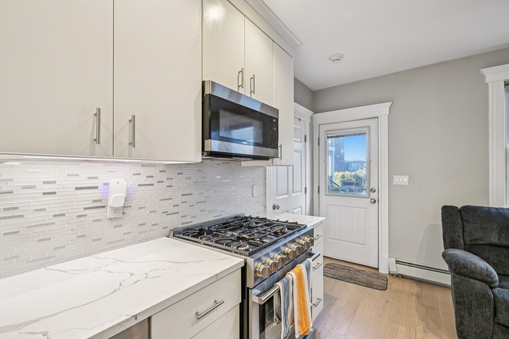 600 Shirley Street, Unit 4 Winthrop, MA 02152 - Photo 15 of 29 a kitchen with granite countertop a stove and a microwave