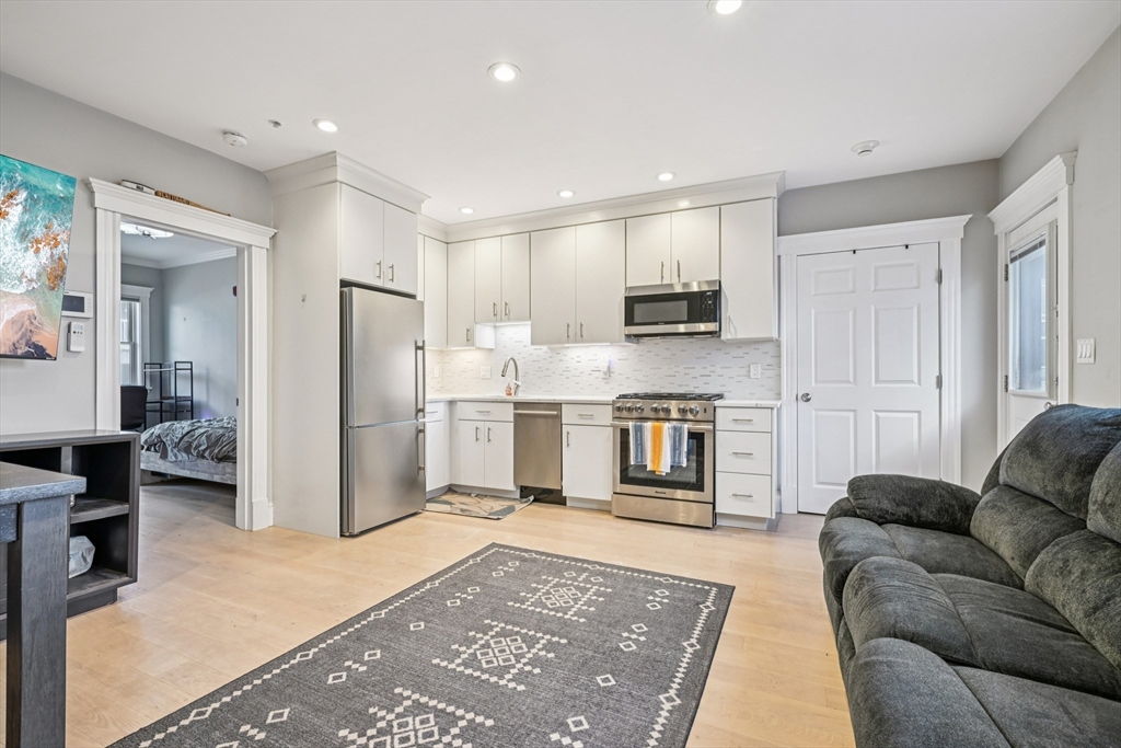 600 Shirley Street, Unit 4 Winthrop, MA 02152 - Photo 10 of 29 a living room with stainless steel appliances furniture a rug and a kitchen