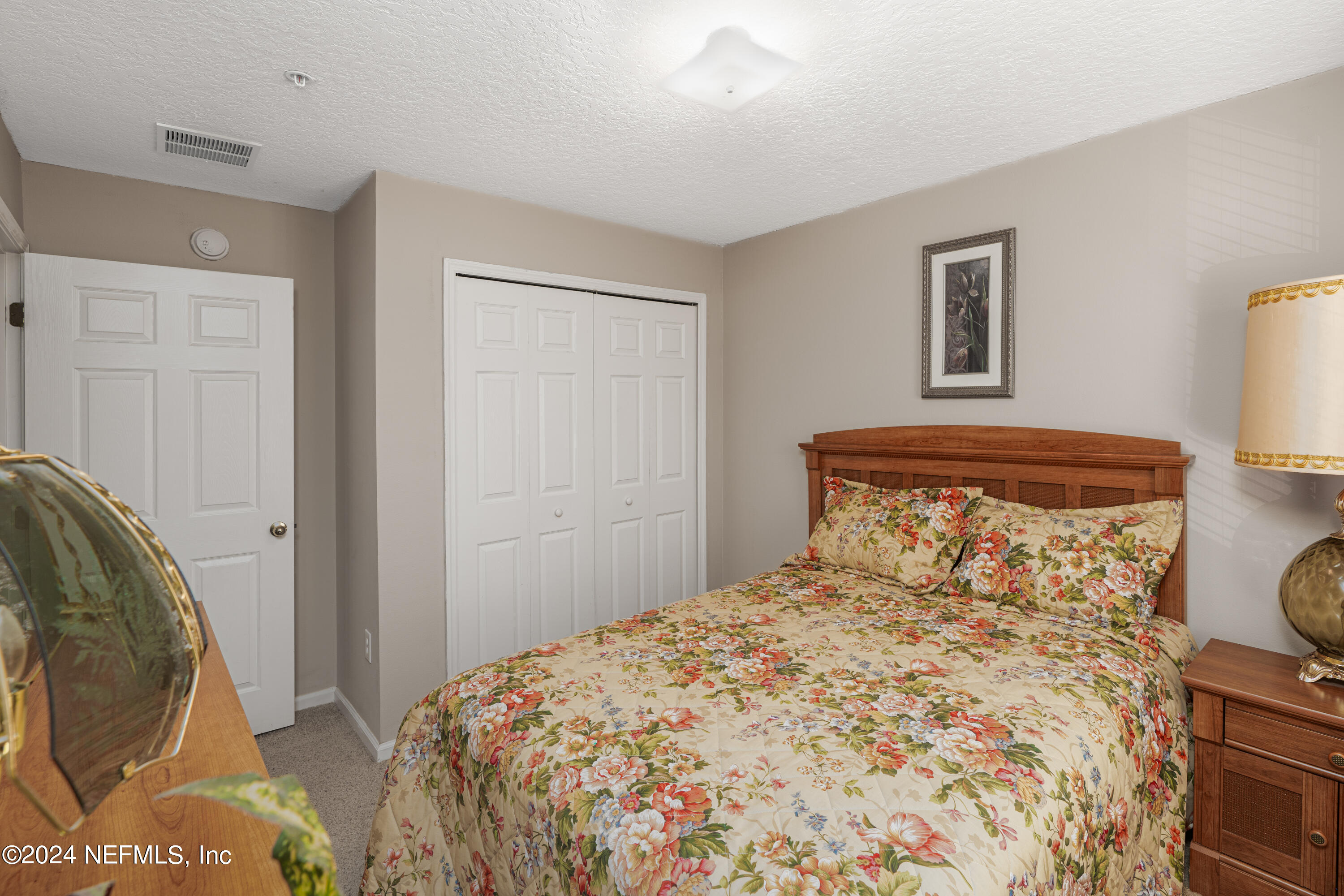 7920 Merrill Road, Unit 709 Jacksonville, FL 32277 - Photo 15 of 25 a bedroom with a bed and wooden floor
