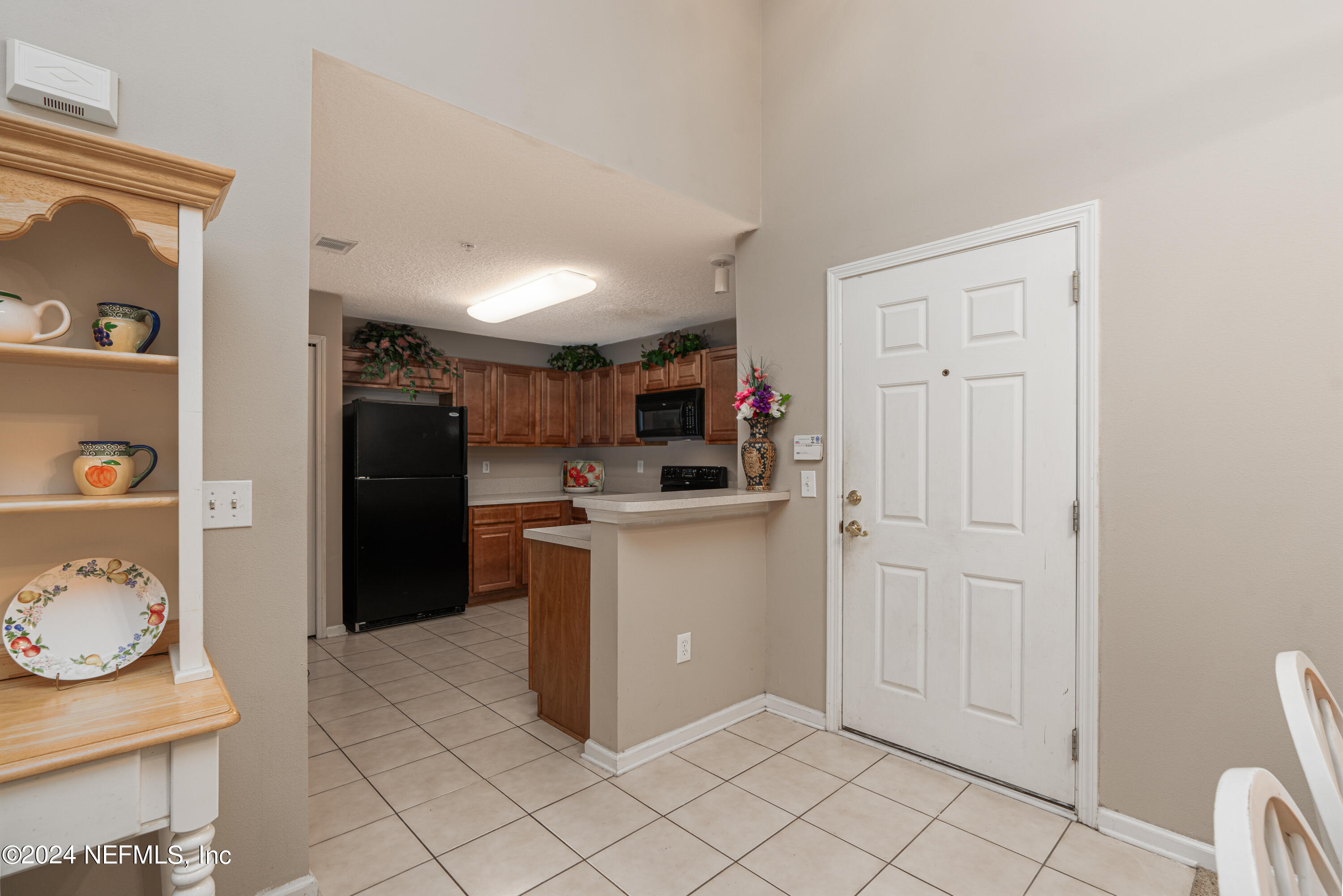 7920 Merrill Road, Unit 709 Jacksonville, FL 32277 - Photo 4 of 25 a kitchen with cabinets and refrigerator