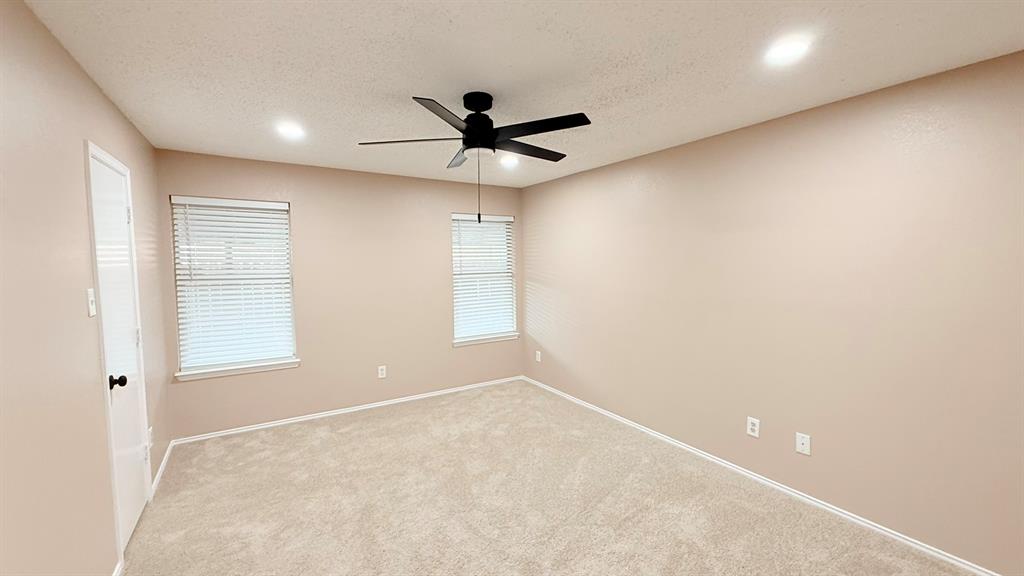 12259 Rim Rock Road Dallas, TX 75253 - Photo 8 of 17 Empty room with a ceiling fan, a textured ceiling, light carpet, and recessed lighting