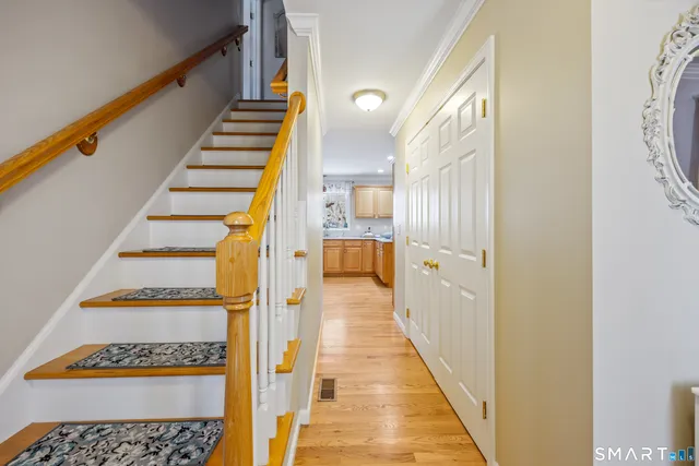 a view of a hallway with wooden floor and staircase