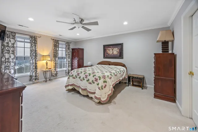 a spacious bedroom with a bed and a chandelier
