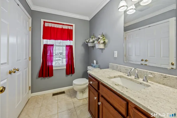 a bathroom with a granite countertop sink a toilet and shower