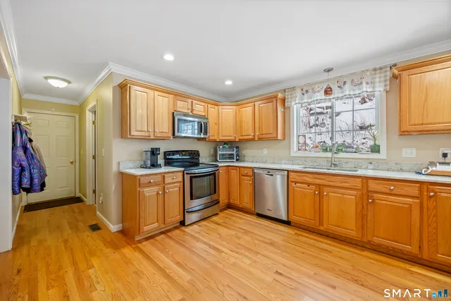 a kitchen with stainless steel appliances granite countertop a stove a sink dishwasher and a refrigerator