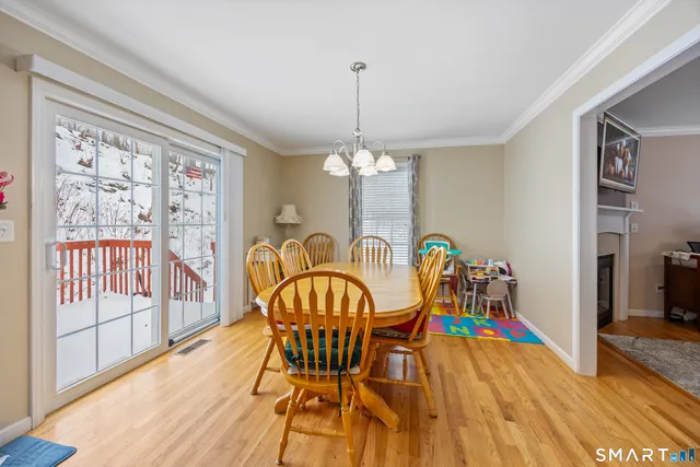 a view of a dining room with furniture a chandelier and wooden floor