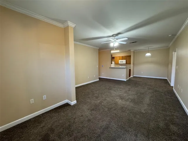 an empty room with windows and ceiling fan