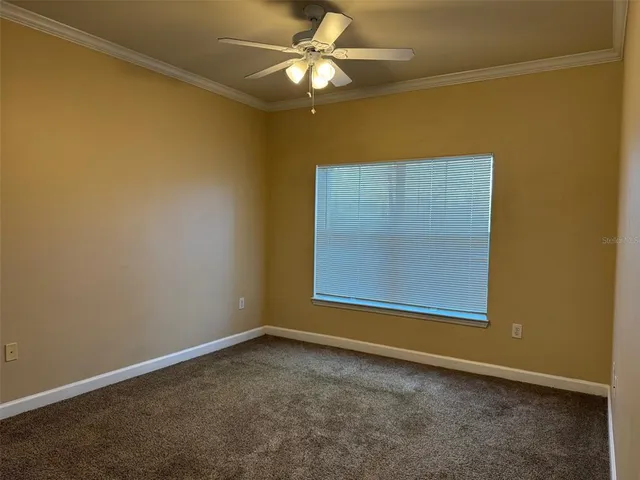 an empty room with a window and a ceiling fan