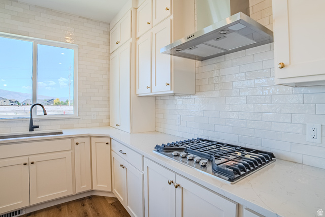 45 North Scarlet Maple Road, Unit 4317 Vineyard, UT 84059 - Photo 11 of 35 Kitchen featuring white cabinetry, quartz countertops, a stainless steel range hood, a stainless steel gas cooktop, and a white subway tile backsplash
