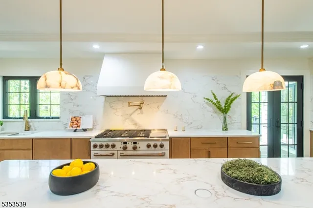 a kitchen with stainless steel appliances kitchen island granite countertop a stove a sink and a wooden floors