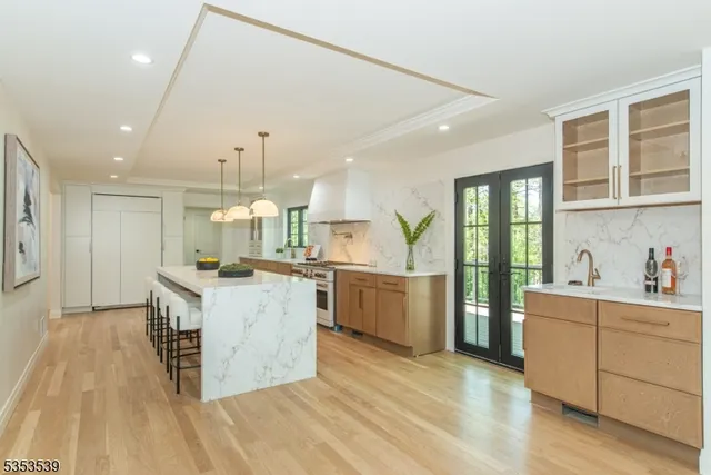 a large kitchen with granite countertop a large counter top and stainless steel appliances