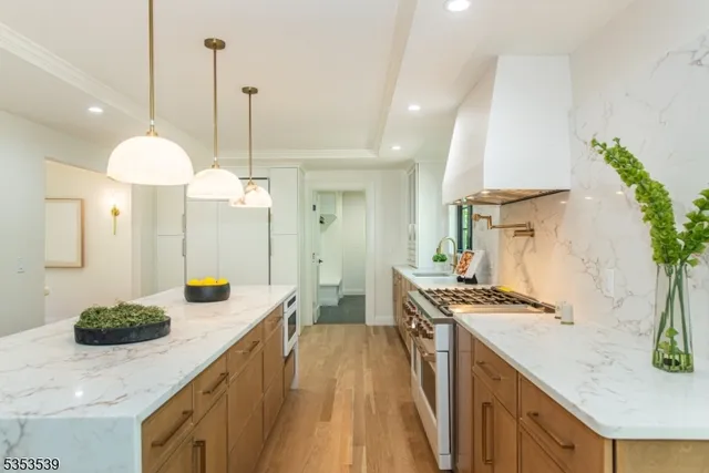 a kitchen with stainless steel appliances kitchen island a stove a sink a refrigerator a stove and a cabinets