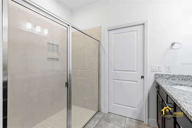 a bathroom with a granite countertop shower and a sink
