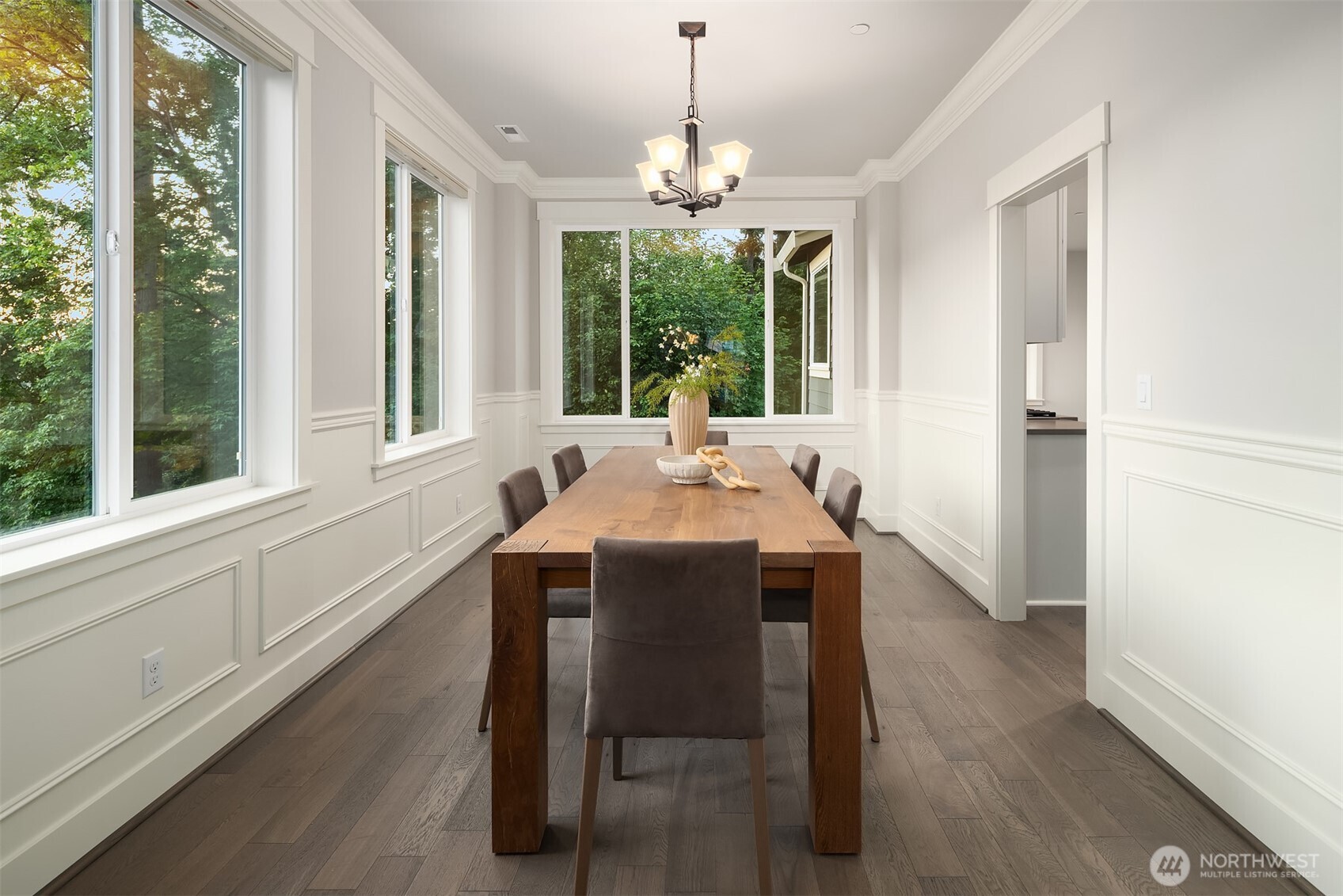 9934 Northeast 162nd Street Bothell, WA 98011 - Photo 4 of 40 a dining room with wooden floor a chandelier a wooden table and chairs