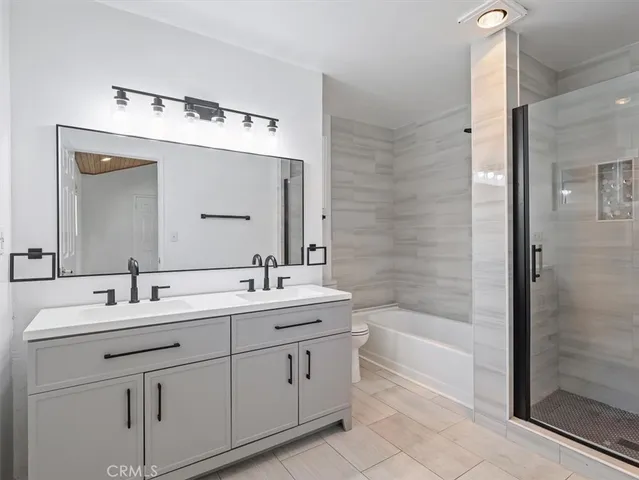 a bathroom with a double vanity sink mirror double and bathtub