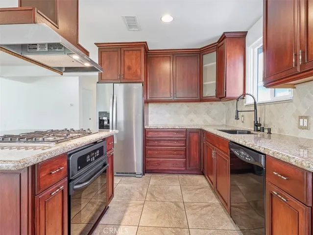 a kitchen with stainless steel appliances granite countertop a stove and a refrigerator