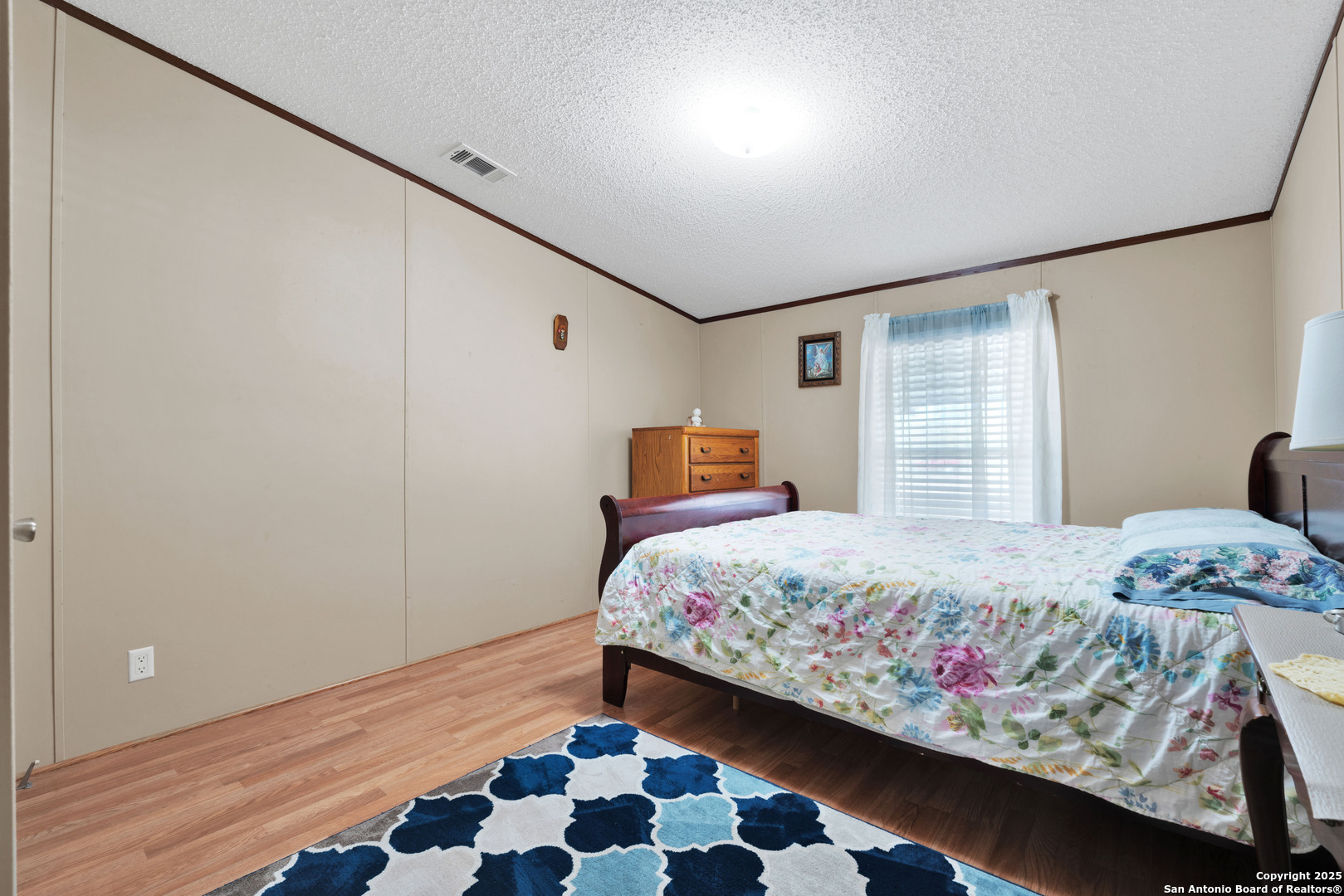 7176 Burshard Road San Antonio, TX 78263 - Photo 13 of 20 a bedroom with a bed and wooden floor