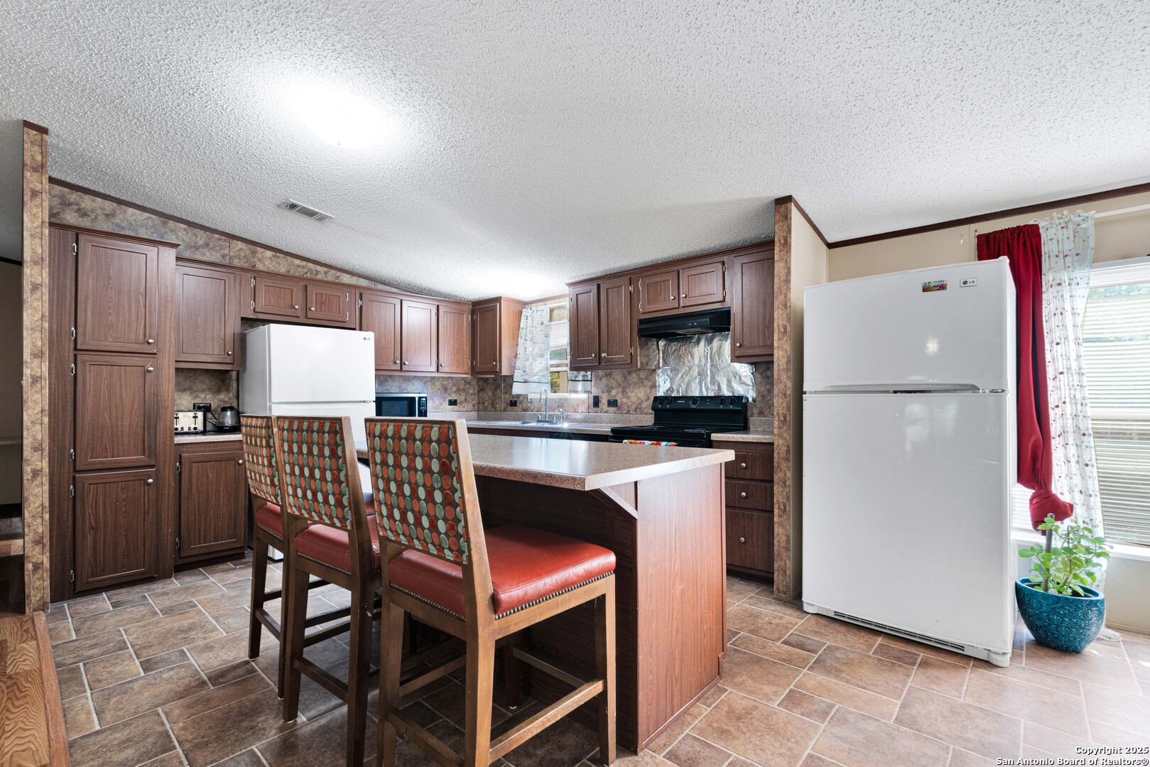 7176 Burshard Road San Antonio, TX 78263 - Photo 7 of 20 a kitchen with stainless steel appliances a refrigerator a stove a sink dishwasher and a refrigerator